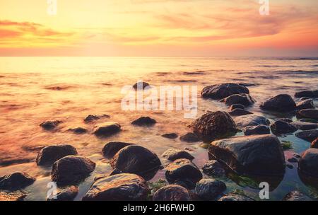 Plage des Rocheuses à un beau coucher de soleil, couleurs appliquées. Banque D'Images