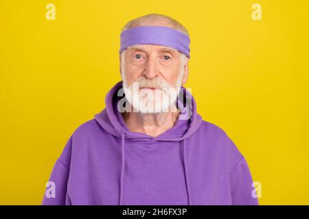 Photo de l'homme âgé confiant sérieux porter des vêtements de sport isolés sur fond jaune Banque D'Images