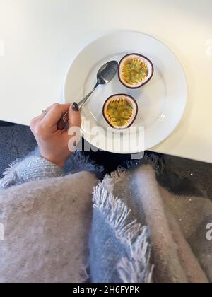 fruit de la passion divisé par deux sur une assiette blanche Banque D'Images