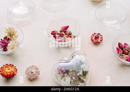 Ornements bricolés de fleurs séchées sur fond de béton beige.Idée de décoration d'arbre de Noël ou de Saint-Valentin.Vue de dessus, plan d'appartement Banque D'Images