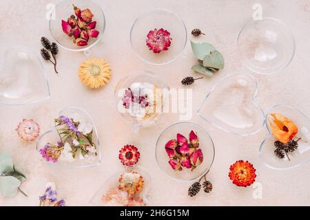 Ornements bricolés de fleurs séchées sur fond de béton beige.Idée de décoration d'arbre de Noël ou de Saint-Valentin.Vue de dessus, plan d'appartement Banque D'Images