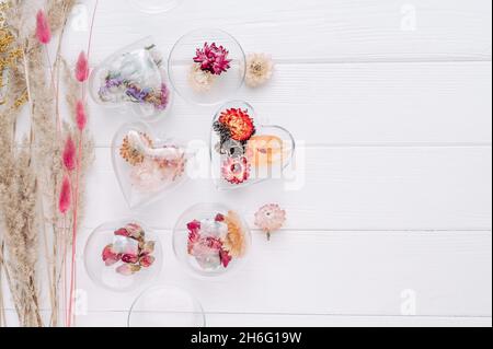 Décorations de bricolage remplies de fleurs séchées sur fond blanc en bois avec espace vide pour le texte.Idée de décoration d'arbre de Noël.Vue de dessus, plan d'appartement. Banque D'Images