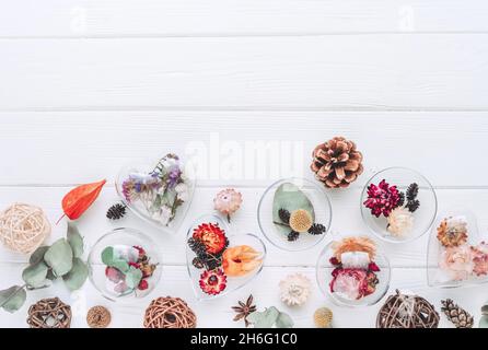 Décorations de bricolage remplies de fleurs séchées sur fond blanc en bois avec espace vide pour le texte.Idée de décoration d'arbre de Noël.Vue de dessus, plan d'appartement. Banque D'Images