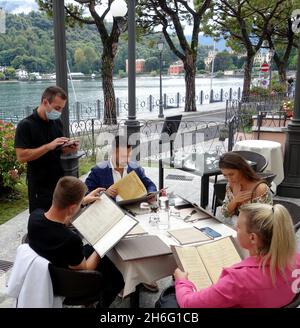 Serveur de restaurant prenant commande auprès des clients à Lenno sur le lac de Côme, Italie Banque D'Images