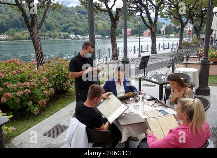 Serveur de restaurant prenant commande auprès des clients à Lenno sur le lac de Côme, Italie Banque D'Images