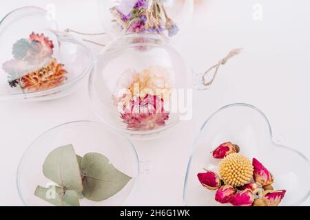 Décorations de bricolage remplies de fleurs séchées sur fond blanc avec espace vide pour le texte.Décoration de Noël.Vue de dessus, plan d'appartement. Banque D'Images