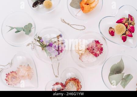 Décorations de bricolage remplies de fleurs séchées sur fond blanc avec espace vide pour le texte.Décoration de Noël.Vue de dessus, plan d'appartement. Banque D'Images