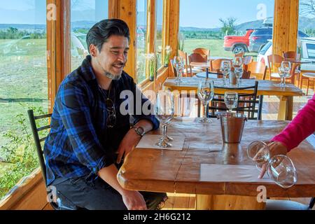 latino garçon assis dans un domaine viticole après une visite guidée du vignoble pour une dégustation de vin. horizontal.Argentine Banque D'Images