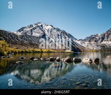 Belle vue sur les montagnes sur le lac calme avec une rangée de pierres sur la surface de l'eau Banque D'Images