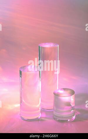 trois podiums en verre transparent sur fond rose pastel Banque D'Images