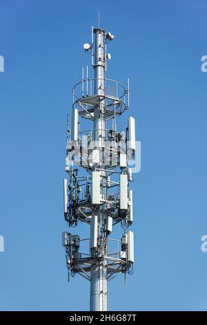 Téléphone cellulaire, tour de télécommunication de téléphone mobile avec antennes sur le ciel bleu Banque D'Images