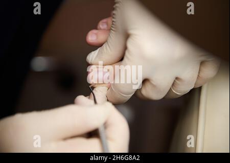 Vue en grand angle d'un podiatre chiropodiste nettoyant les pieds de femme dans le salon de beauté.Gros plan Banque D'Images