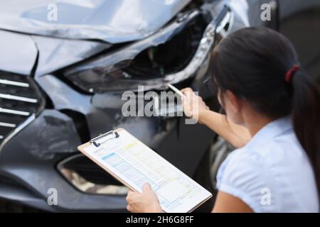 L'agent d'assurance enregistre les dommages causés à la voiture après un accident Banque D'Images