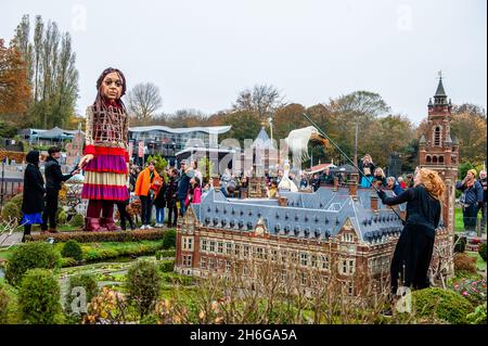 Little Amal est vu à la recherche d'une marionnette d'un oiseau volant au-dessus du bâtiment miniature du Palais de la paix.Amar, un nouveau centre culturel dans le centre de la Haye a organisé dans le cadre de son 'Open Festival', la visite de la marionnette géante 'Little Amal',Une jeune fille syrienne de neuf ans et plus de 11 mètres de hauteur jusqu'au parc miniature Madurodam.Elle est invitée à participer au Festival en tant qu'invitée spéciale dans la ville pour attirer l'attention à travers l'Europe sur le sort des jeunes réfugiés qui ont fui la Syrie.Amal a été reçu à l'extérieur du parc par un groupe d'enfants, après qu'elle a pu marcher autour de la 1:2 Banque D'Images