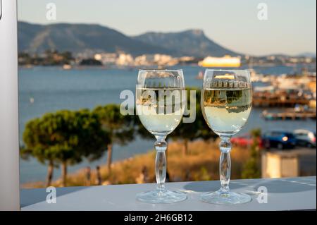 Été sur la Côte d'Azur, boire du vin blanc froid des Côtes de Provence sur une terrasse extérieure avec vue sur le port de Toulon, Var, France Banque D'Images