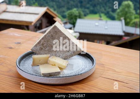 Collection de fromages, tomme de savoie et village de montagnes françaises en haute-Savoie en été en arrière-plan Banque D'Images