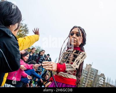 On voit des enfants tenter de toucher la main de Little Amal.Amara, un nouveau centre culturel au centre de la Haye, a organisé dans le cadre de son « Open Festival », la visite de la marionnette géante « Little Amal », une jeune fille réfugiée syrienne de neuf ans et de plus de 11 mètres de haut au parc miniature,Madurodam.Elle est invitée à participer au Festival en tant qu'invitée spéciale dans la ville pour attirer l'attention à travers l'Europe sur le sort des jeunes réfugiés qui ont fui la Syrie.Amal a été reçu à l'extérieur du parc par un groupe d'enfants, après qu'elle a pu se promener autour de l'échelle 1:25 répliques modèle de célèbre néerlandais l Banque D'Images