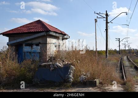 La maison d'un lineman connu est vue sur les chemins de fer abandonnés dans le village de Verkhnocketske.Verkhetske est un village ukrainien de type urbain situé sur la ligne de front même dans le district de Yasynuvata dans l'oblast de Donetsk dans l'est de l'Ukraine.Au cours de la guerre du Donbass, qui a débuté à la mi-avril 2014, la ligne de séparation entre les parties belligérantes a été située à proximité de la colonie.Le village était une zone grise jusqu'à la fin de 2017.Aujourd'hui, Verkhnocketske est un territoire de l'Ukraine.Le conflit a fait des victimes tant civiles que militaires. Banque D'Images