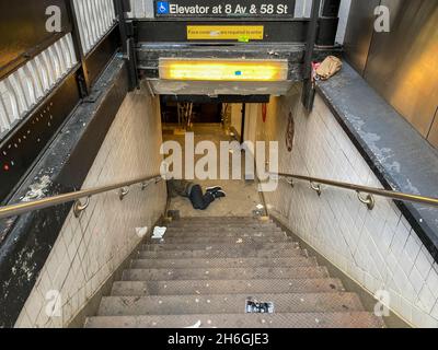 Un homme sans abri dort à l'entrée d'une station de métro à New York le dimanche 7 novembre 2021.(© Frances M. Roberts) Banque D'Images