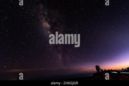 Vue nocturne depuis le parc national de Haleakala, avec l'Observatoire et la voie lactée en arrière-plan - Maui, Hawaii, États-Unis. Banque D'Images