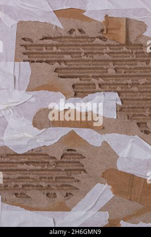 Arrière-plan vertical abstrait - un morceau de carton d'emballage ondulé avec des morceaux de ruban auto-adhésif collés pour la conception Banque D'Images