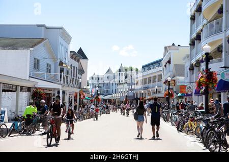 Touristes marchant et à vélo sur la rue principale de l'île Mackinac Banque D'Images