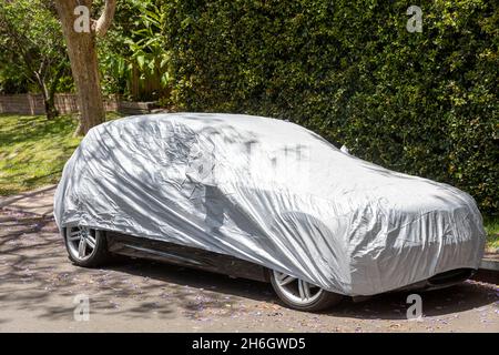 Voiture garée dans la rue de Sydney en Australie, avec housse de protection contre la pluie de voiture à travers le véhicule, Australie Banque D'Images