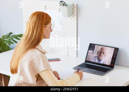 Portrait d'une femme aux cheveux rouges travaillant à la maison lors d'une réunion en ligne avec le responsable, espace de copie Banque D'Images