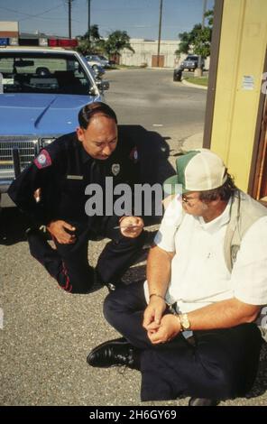 Austin Texas USA, 1989: L'agent de police lit Miranda le droit de cambriolage suspect dans le stationnement après capture.M. RE-299 ©Bob Daemmrich Banque D'Images