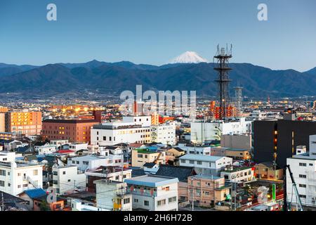 Kofu, Japon ville avec Mt. Fuji avec un pic sur les montagnes au crépuscule. Banque D'Images