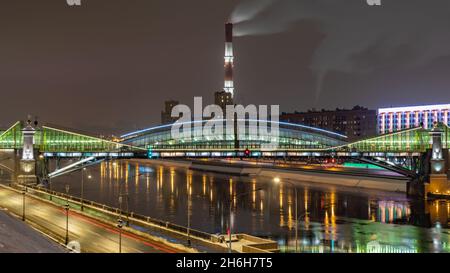 Vue sur le pont coloré Bogdan Khmelnitsky illuminé la nuit et réfléchissant dans la rivière Moskova.Pont piétonnier traversant la rivière Moskva.Moscou Banque D'Images