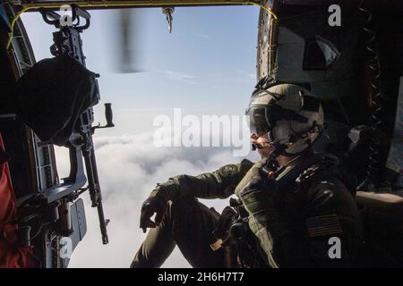 210904-N-JW440-4024 (sept4, 2021) hélicoptère Crewman (tactique) de l'Air naval de 2e classe Connor Olson effectue des tâches de surveillance à bord d'un hélicoptère MH-60R Seahawk, attaché aux « Saberhawks » de l'Escadron de frappe maritime (HSM) 77 déployé avec le croiseur à missiles guidés USS Shiloh (CG 67) dans la mer d'Arabie Saoudite du Nord, le 4 septembre.Shiloh est déployé dans la zone d'opérations de la 5e flotte des États-Unis à l'appui des opérations navales afin d'assurer la stabilité et la sécurité maritimes dans la région centrale, reliant la Méditerranée et le Pacifique par l'océan Indien occidental et trois points d'étranglement stratégiques.(É.-U.Bleu marine Banque D'Images