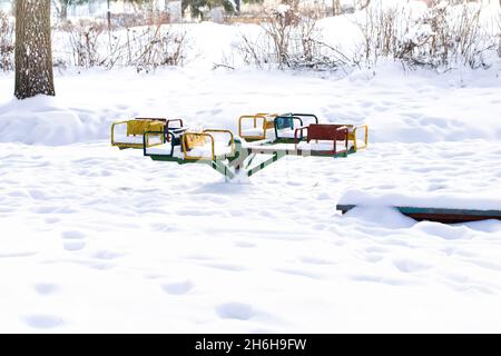 Carrousel pour enfants après une chute de neige sans enfants dans le parc.Russie. Banque D'Images