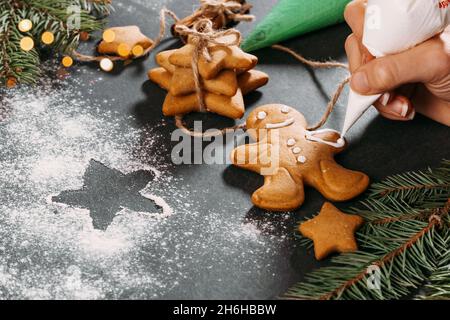 Arrière-plan de Noël avec biscuits maison d'homme de pain d'épice couverts de glace sur table noire, espace de copie.Repas de fête, carte postale, fête Banque D'Images