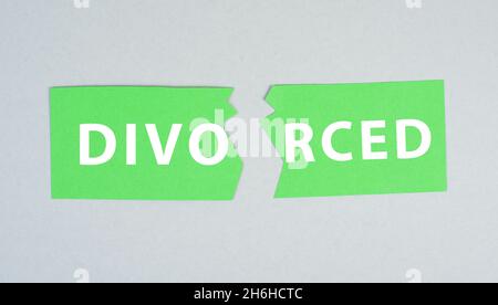 Papier vert déchiré avec le mot divorcé sur fond gris, fin du mariage, séparation, relation Banque D'Images