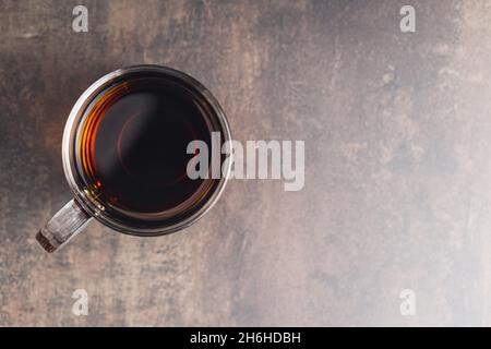 Thé dans une tasse en verre sur une table ancienne.Vue de dessus. Banque D'Images