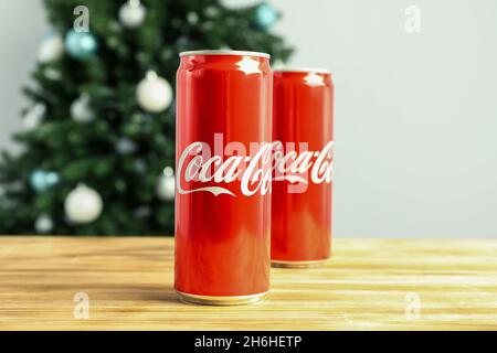 Odessa, Ukraine - 20 octobre 2021 : Composition en arbre de Noël faite de canettes de Coca-Cola sur une table en bois Banque D'Images