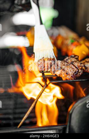 Griller de la viande avec une flamme sur un barbecue Banque D'Images