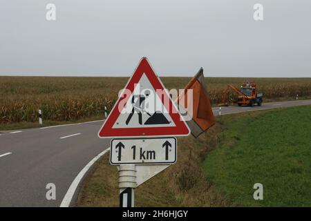 Le travail de tonte et son panneau routier sur une route fédérale en Allemagne Banque D'Images