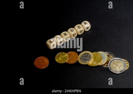 L'inscription sur les cubes, le mot TAXE en allemand sur les cubes de texture en bois avec des pièces de monnaie autour Banque D'Images