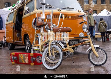 Raleigh cycles et skateboard devant un campervan classique de VW au London Classic car Boot sale, King's Cross, Londres, Royaume-Uni Banque D'Images