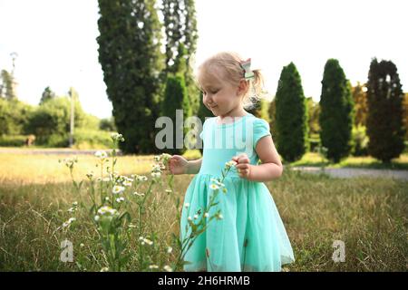 Portrait d'une heureuse liitle blonde fille gros plan.3 yaers caucasienne todler fille souriant à l'extérieur de marche.Danse d'enfants et crier montrant différents emo Banque D'Images