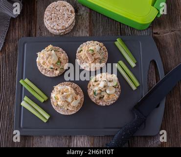 Préparez le repas pour la forme physique ou la musculation avec une salade de thon riche en protéines et à faible teneur en gras, accompagnée de craquelins de riz brun et de bâtonnets de céleri frais Banque D'Images