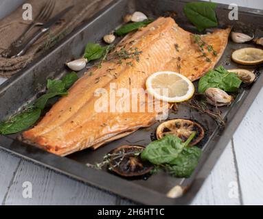 Demi-saumon rôti au four avec herbes, huile d'olive et citron Banque D'Images