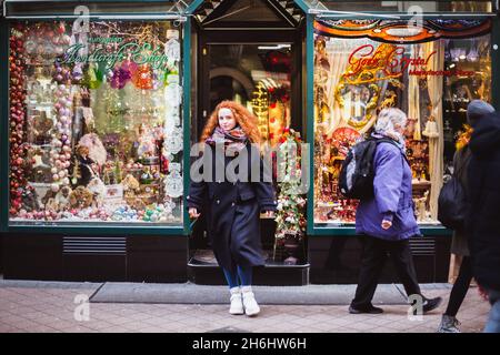 BUDAPEST, HONGRIE - 08 NOVEMBRE 2019: Fille de cheveux rouges appréciant le marché européen de Noël avec la foule de gens sur fond.Lumières floues et colorées Banque D'Images