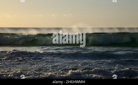 Fuerteventura, côte ouest, puissantes vagues de l'océan au coucher du soleil, partiellement translucides Banque D'Images