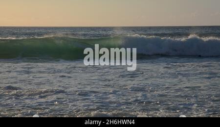 Fuerteventura, côte ouest, puissantes vagues de l'océan au coucher du soleil, partiellement translucides Banque D'Images