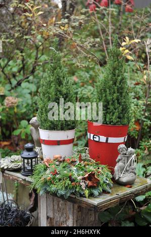 Décoration de Noël dans un jardin.Couronne de Noël en faux cyprès et sapin sur une table en bois Banque D'Images