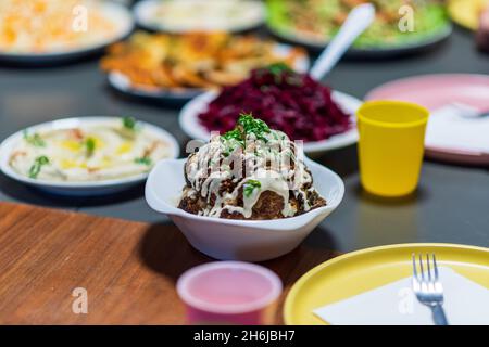 Une tête entière de chou-fleur rôti aux ingrédients de la torréfaction et à la sauce tahini.Alimentation santé Moyen-Orient.Cuisine méditerranéenne et balkanique.Photo de haute qualité Banque D'Images