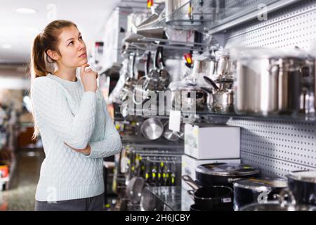 La jeune femme choisit des plats pour sa maison Banque D'Images